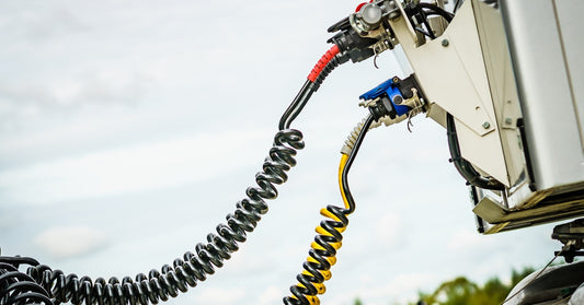 The color-coded coiled air supply brake lines for a semi-truck air valve system. The lines are attached to a trailer.