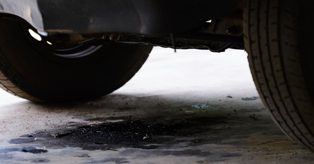 A puddle of fuel leaking from the semi-truck idling above—the puddle is small but indicative of a larger problem.